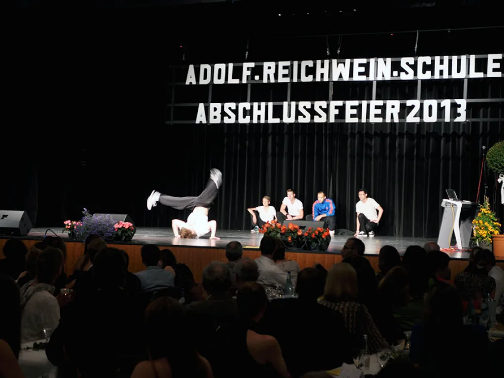 Auftritt auf der Bühne vor der Schriftwand.